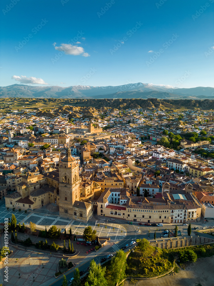 Vertical drone perspective of medieval city Guadix. Situated in Granada province, Spain is a famous travel destination. Sunset point with warm colours reflecting on budlings. Sierra Nevada Mountain