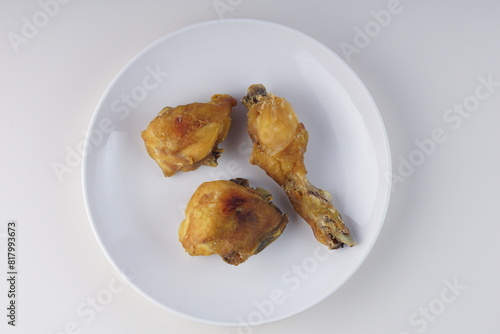 pieces of fried chicken on a white plate on a white table with studio lighting