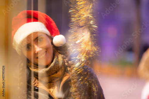 junge attraktive Frau beim shoppen auf dem Weihnachtsmarkt, Lichterglanz und weihnachtliche Stimmung in der Stadt.