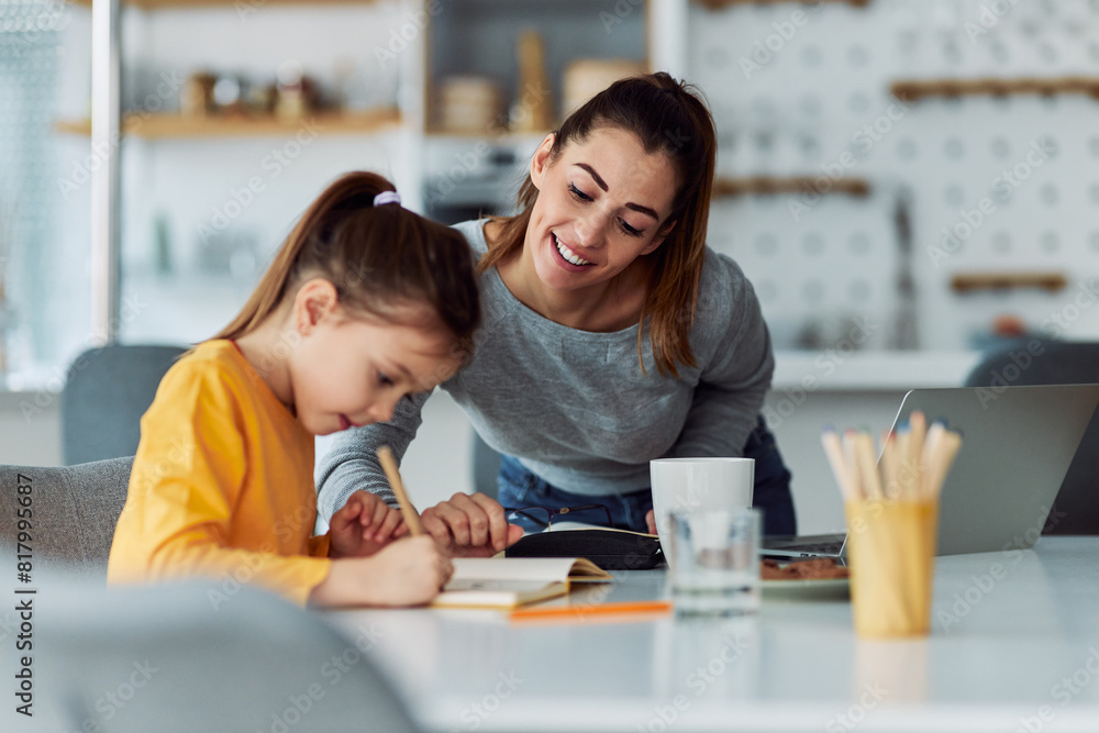 A loving mother gently guiding and helping her daughter through homework A loving mother gently guiding and helping her daughter through homework