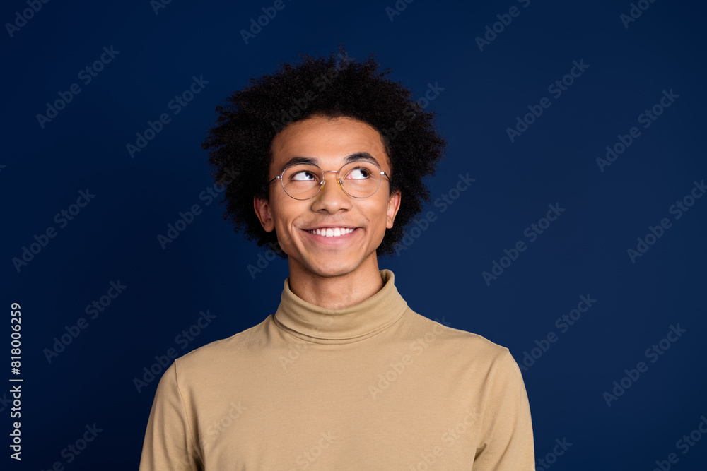 Photo portrait of attractive young man look empty space dressed stylish beige clothes isolated on dark blue color background Photo portrait of attractive young man look empty space dressed stylish beige clothes isolated on dark blue color background