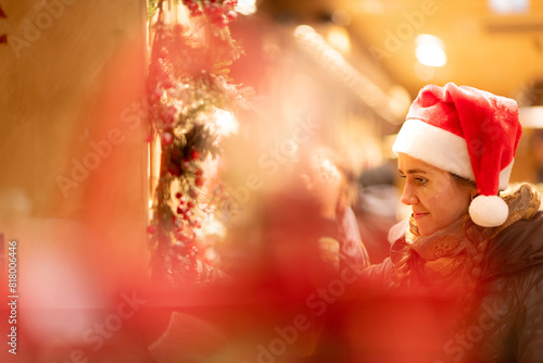 junge attraktive Frau beim shoppen auf dem Weihnachtsmarkt, Lichterglanz und weihnachtliche Stimmung in der Stadt.