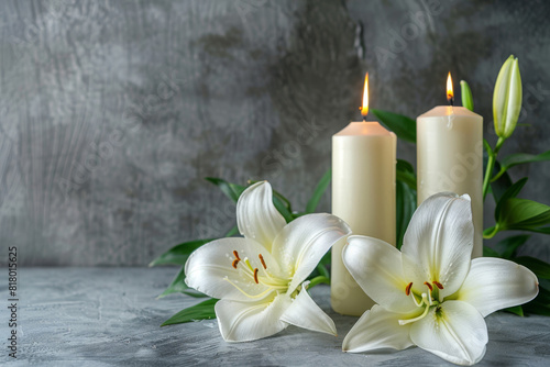 Tranquil condolence background featuring two lit candles alongside pristine white lilies against a soft, textured grey backdrop