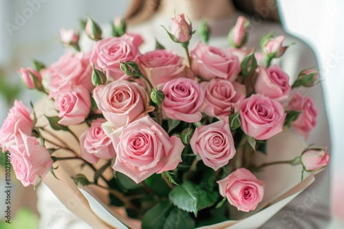 Closeup of Woman holding a Beautiful Pink Bouquet of Roses on Light Background