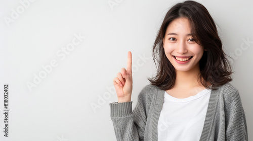 Japanese woman happily gestures, pointing to her temple.