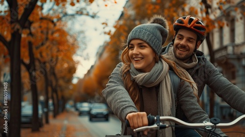 Smiling young couple bike riding on urban autumn street - 