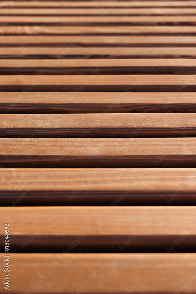 Wooden slats are painted with brown antiseptic or tinted with transparent paint. Close-up. Selective focus. Wooden slats are painted with brown antiseptic or tinted with transparent paint. Close-up. Selective focus.