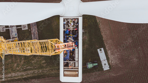 Green wind energy from renewable sources and zero carbon footprint. Wind turbine repaired by workers, maintenance of turbine
