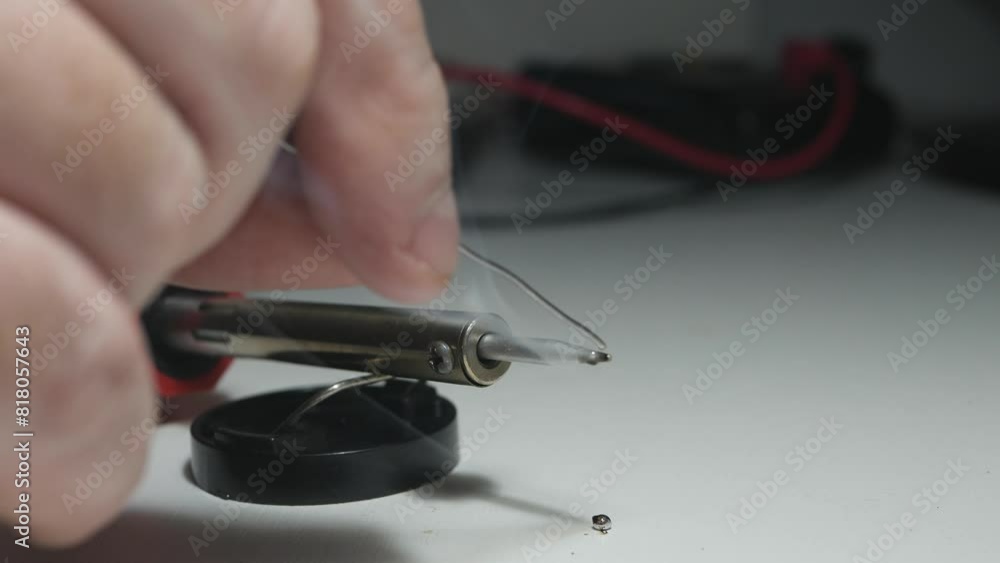 Blurred Shooting with a Technician Who Prepares a Hot Soldering Tool for the Repair of Electronic Boards in a Service. Men Repairing Using Electronic Technology. Blurred Shooting with a Technician Who Prepares a Hot Soldering Tool for the Repair of Electronic Boards in a Service. Men Repairing Using Electronic Technology.