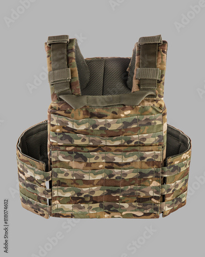 Detailed view of modern camouflage military tactical vest with MOLLE system, multiple pouches, and heavy-duty buckles, isolated on grey background photo