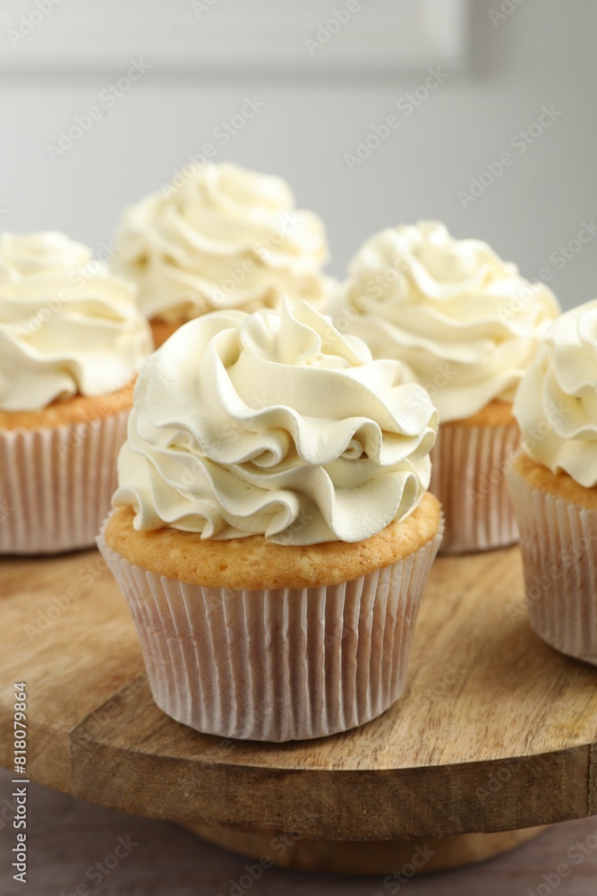 Tasty cupcakes with vanilla cream on pink wooden table, closeup Tasty cupcakes with vanilla cream on pink wooden table, closeup