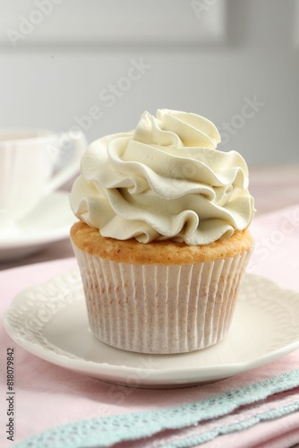 Tasty cupcake with vanilla cream on table, closeup