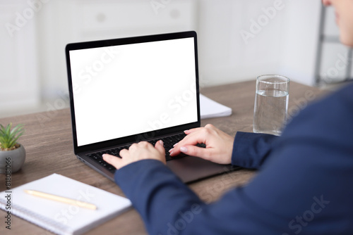 Woman watching webinar at wooden table in office, closeup