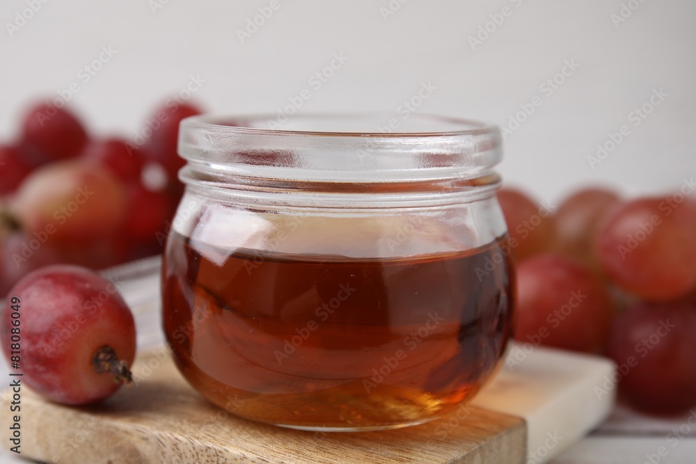 Wine vinegar in glass jar and grapes on table, closeup Wine vinegar in glass jar and grapes on table, closeup