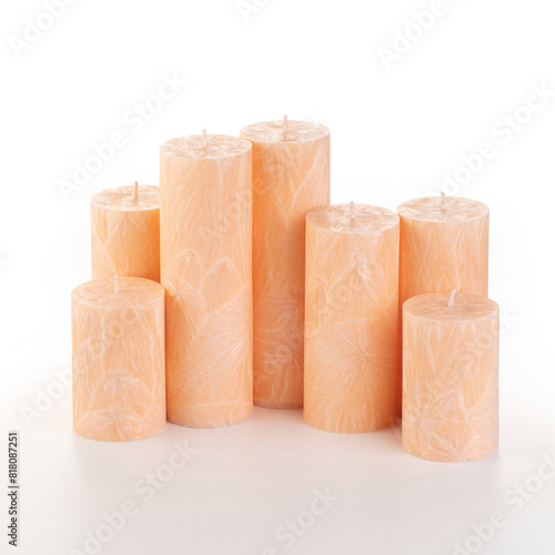 Natural peach palm wax pillar candles of varying heights; featuring unique ice pattern texture grouped on white background. Handmade accessories for refreshing interior decor