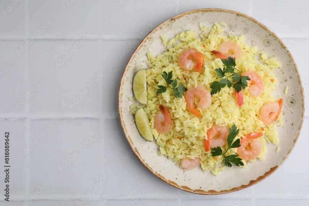 Delicious risotto with shrimps, lime and parsley on white tiled table, top view. Space for text Delicious risotto with shrimps, lime and parsley on white tiled table, top view. Space for text