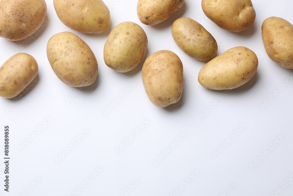 Fresh raw potatoes on white background, flat lay. Space for text Fresh raw potatoes on white background, flat lay. Space for text
