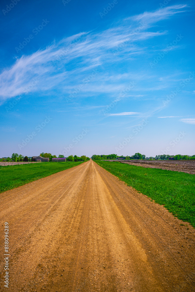 Dirt road, horizon, and the big sky: Tranquil midwestern farmland summer landscape in Hartford, Minnehaha County, South Dakota Dirt road, horizon, and the big sky: Tranquil midwestern farmland summer landscape in Hartford, Minnehaha County, South Dakota