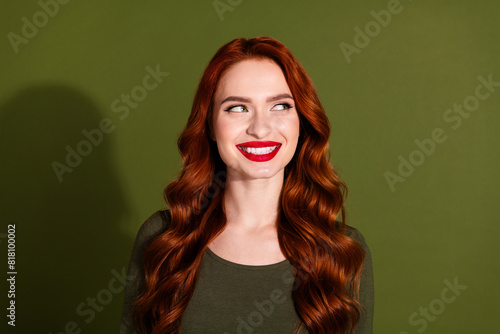 Photo of shiny attractive lady dressed shirt smiling looking empty space isolated green color background © deagreez