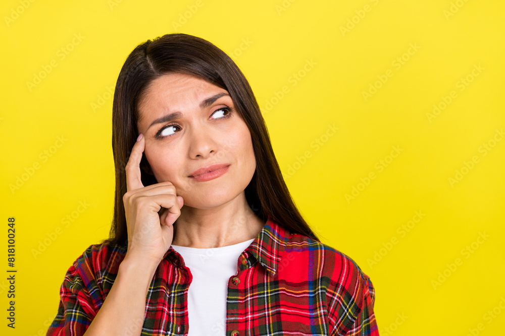 Photo of unsure pretty lady wear plaid shirt looking empty space isolated yellow color background Photo of unsure pretty lady wear plaid shirt looking empty space isolated yellow color background