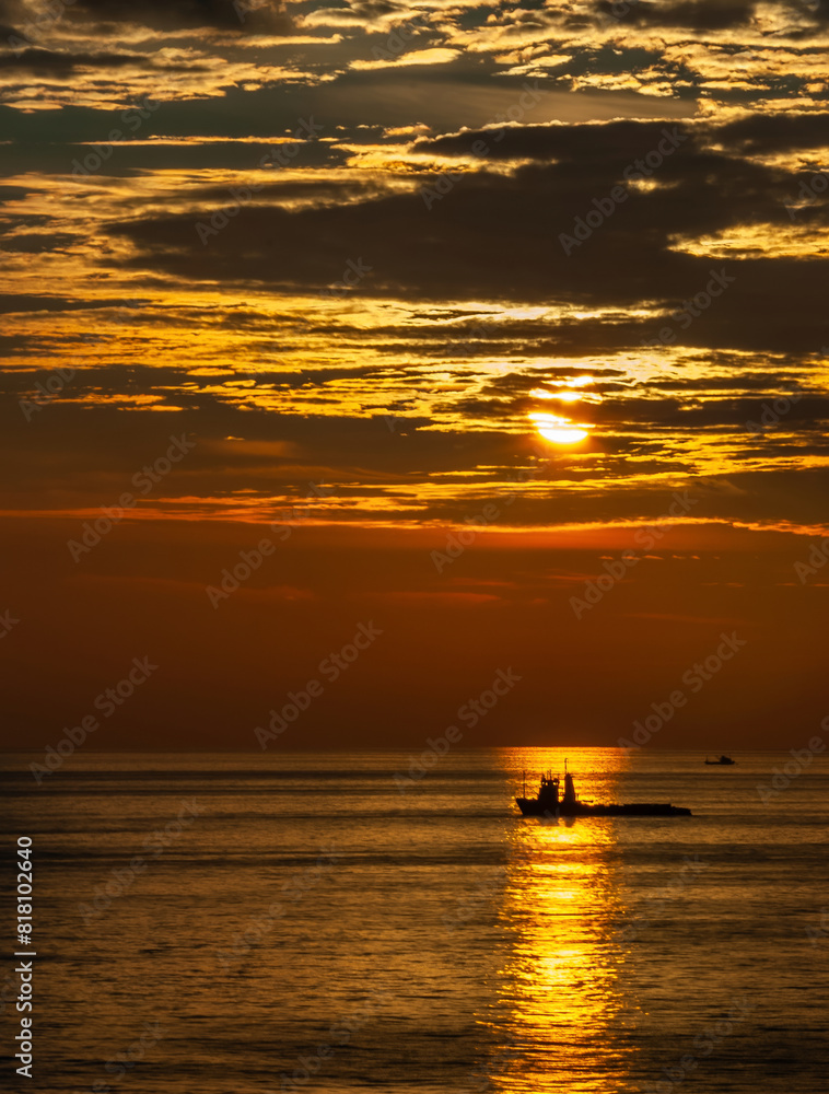 Silhouette boat on beautiful sunset sky background vertical format