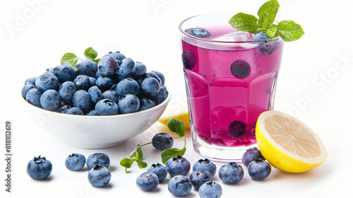 Glass of fresh blueberry lemonade and bowl with berries