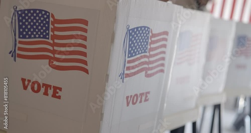 Close up, camera moves from front of row of voting booths, to side, and back at polling station in United States. Camera on stabilized gimbal, 4K DCI