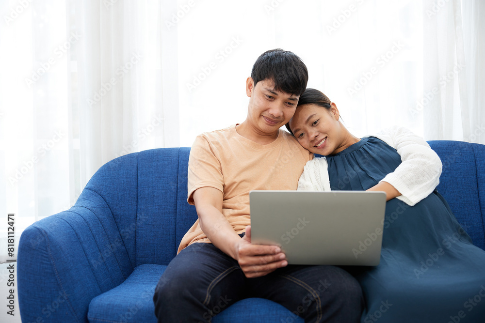pregnant woman with her husband doing online shopping from laptop computer at home pregnant woman with her husband doing online shopping from laptop computer at home