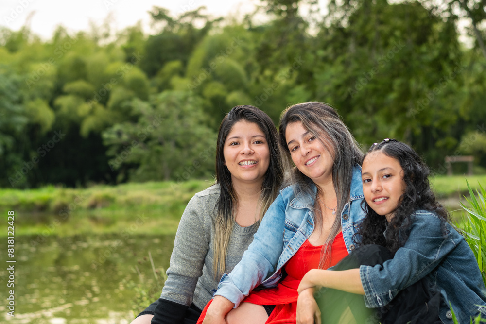 three latina girls sitting together on the lawn by the fishing lake three latina girls sitting together on the lawn by the fishing lake