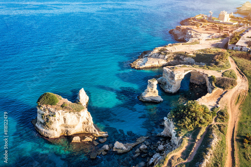 Stunning seascape with cliffs rocky arch and stacks (Faraglioni) at Torre Sant Andrea, Salento coast, Puglia region, Italy. Beautiful cliffs and sea stacks of Sant'Andrea, Salento, Apulia, Italy photo