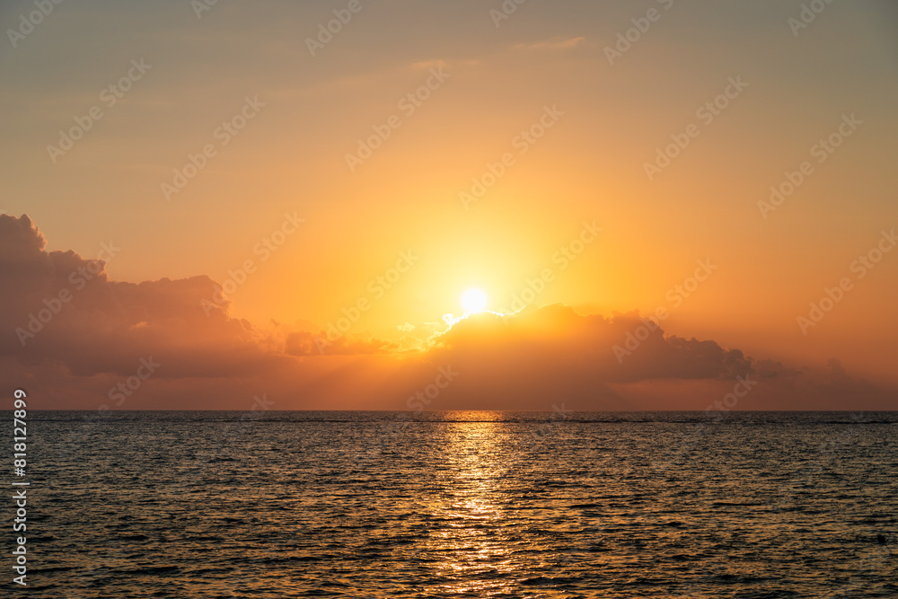 Dramatic colorful sunset sky over sea. Cloudscape nature background. Beautiful sunset over the sea. Sunset over the sea and beautiful cloudscape.