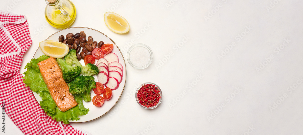 Healthy lunch with grilled salmon on green lettuce, next to vegetables, tomatoes, radishes, broccoli and a portion of beans. Healthy lunch with grilled salmon on green lettuce, next to vegetables, tomatoes, radishes, broccoli and a portion of beans.