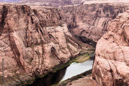 The left side of Horseshoe Bend Canyon with boat on the Colorado River, also reflection of canyon in water.