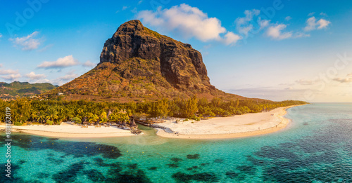 Beach with palm trees and umbrellas on Le morne beach in Mauriutius. Luxury tropical beach and Le Morne mountain in Mauritius. Le Morne beach with palm trees  white sand and luxury resorts  Mauritius