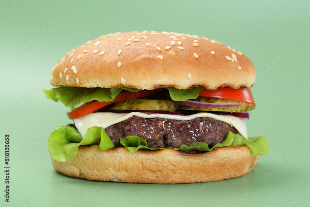 Burger with delicious patty on green background, closeup Burger with delicious patty on green background, closeup