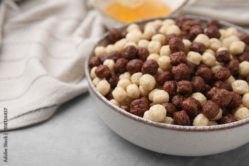 Tasty cereal balls in bowl on grey table, closeup. Space for text Tasty cereal balls in bowl on grey table, closeup. Space for text