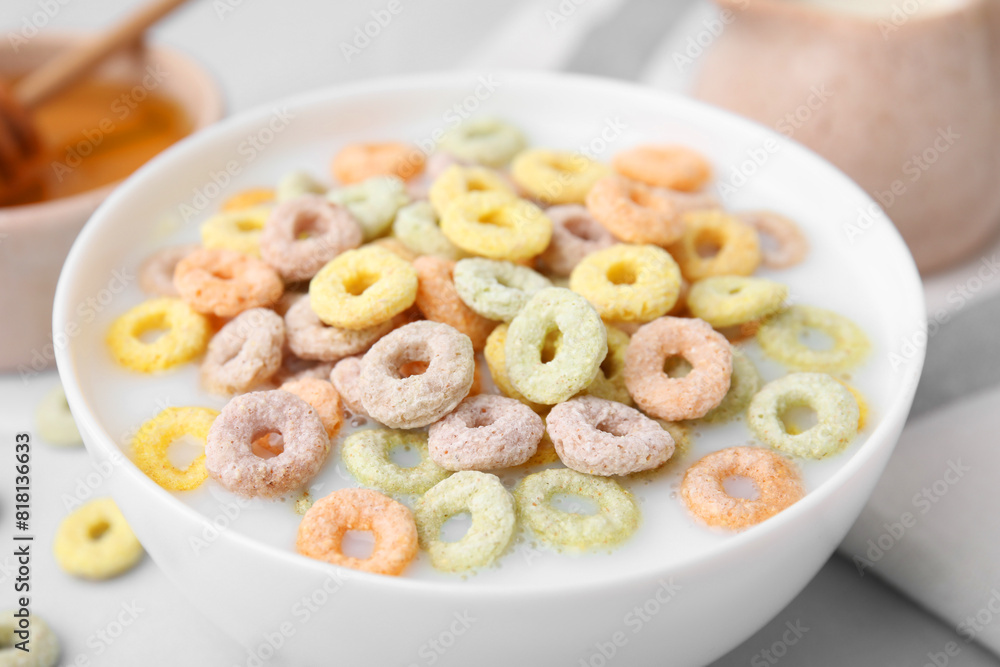 Cereal rings and milk in bowl on white table, closeup Cereal rings and milk in bowl on white table, closeup