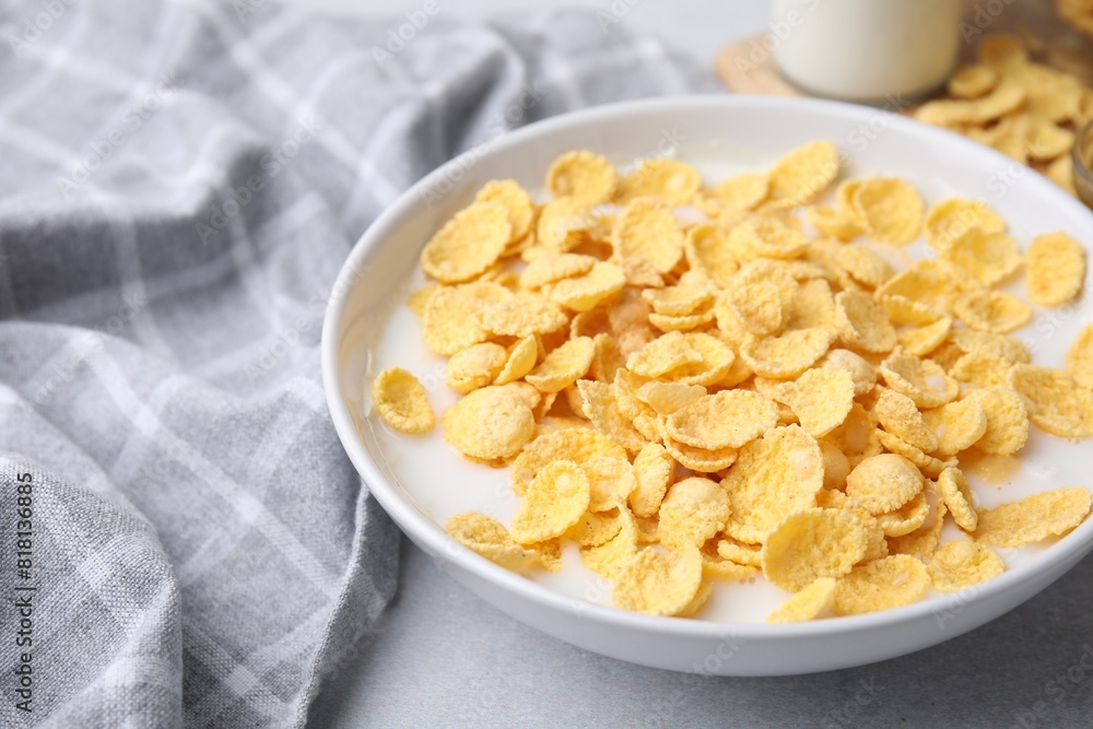 Breakfast cereal. Corn flakes and milk in bowl on light grey table, closeup Breakfast cereal. Corn flakes and milk in bowl on light grey table, closeup