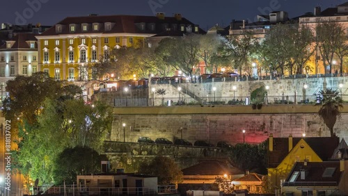 Aerial view over the center of Lisbon to the viewpoint called: Miradouro de Sao Pedro de Alcantara night timelapse. Funicular Gloria going up and down. People in the park. Portugal photo