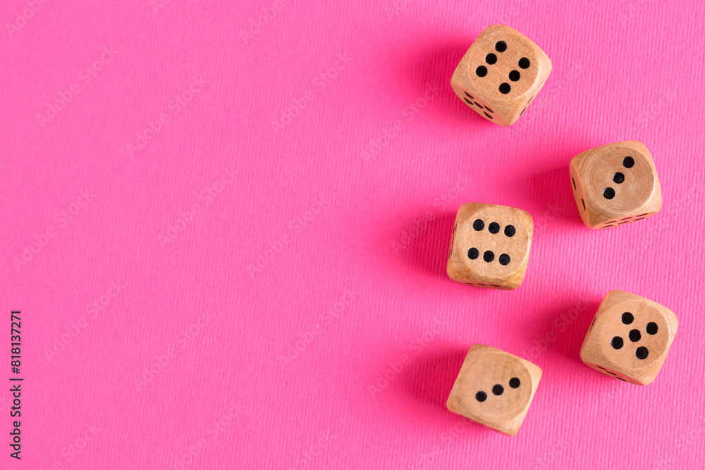 Many wooden game dices on pink background, flat lay. Space for text
