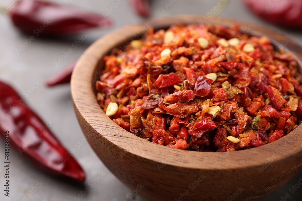 Chili pepper flakes in bowl on table, closeup Chili pepper flakes in bowl on table, closeup
