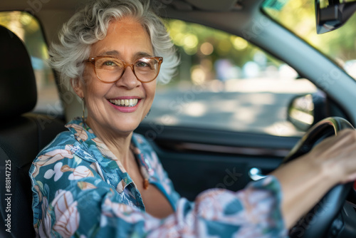 Cheerful senior lady driving her car independently, delighting in the ride. Emphasizing safe driving practices for older adults, ensuring road safety. Latino.