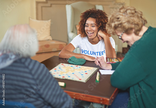 Volunteer, woman and happiness with senior people in retirement home, board game and social interaction for advocacy. African girl, elderly women and scrabble for volunteering and community service. photo