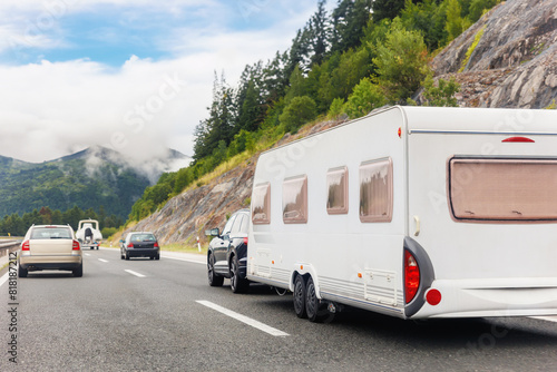 Scenic view big modern white family rv camper van vehicle drive Europe highway road alpine mountain cloud in summer day. Rving motorhome lifestyle travel and adventure tourism trip journey concept photo