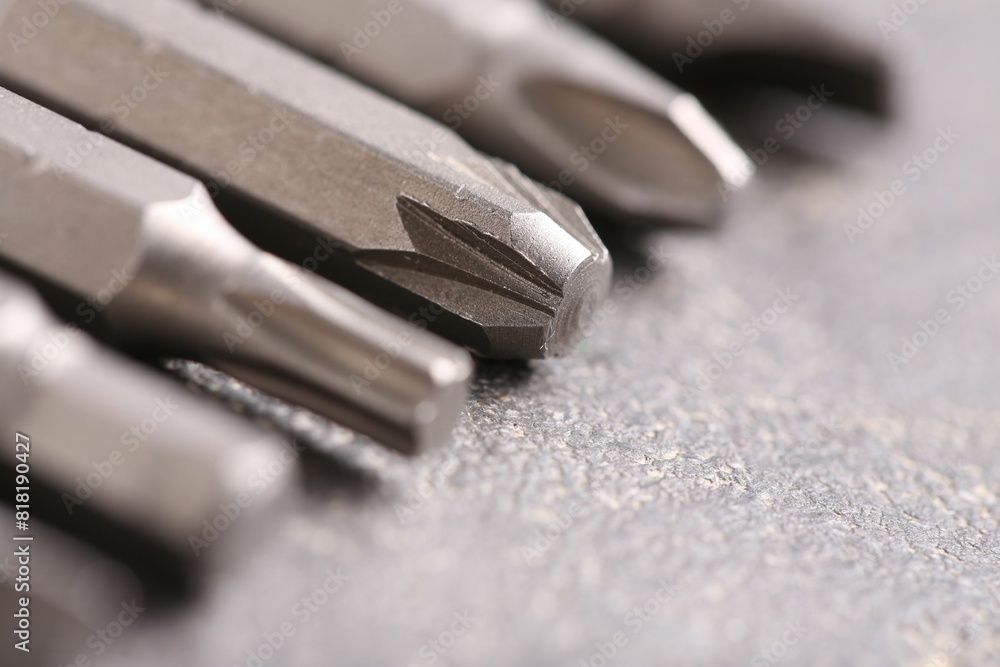 Different screwdriver bits on grey table, closeup