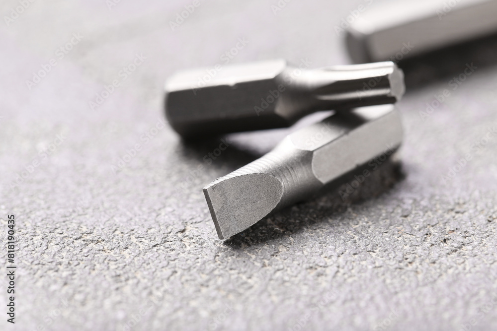 Different screwdriver bits on grey table, closeup Different screwdriver bits on grey table, closeup