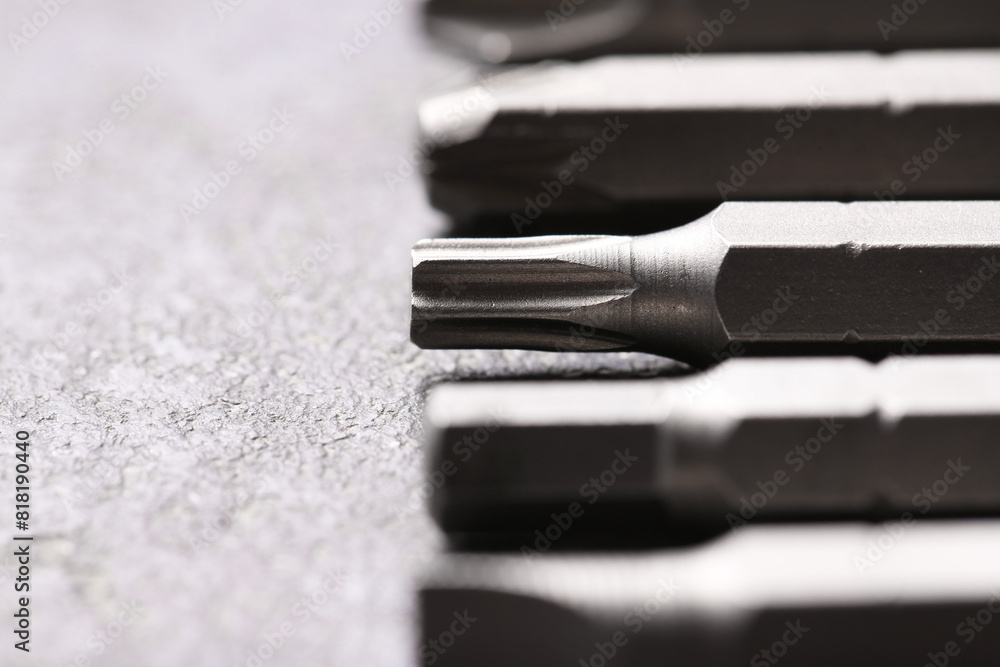 Different screwdriver bits on grey table, closeup