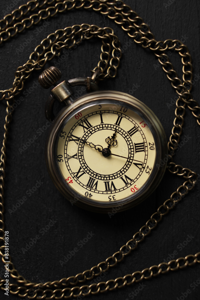 Pocket clock with chain on black wooden table, top view Pocket clock with chain on black wooden table, top view