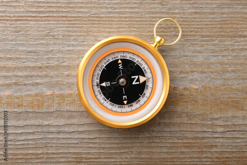 One compass on wooden table, top view