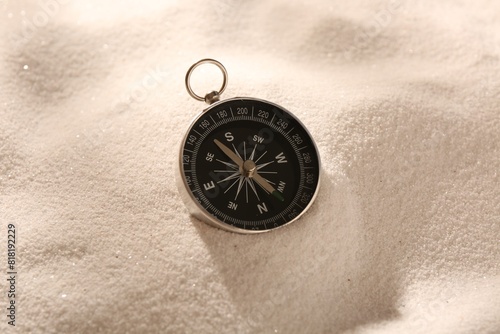 One compass on beach sand. Navigation equipment